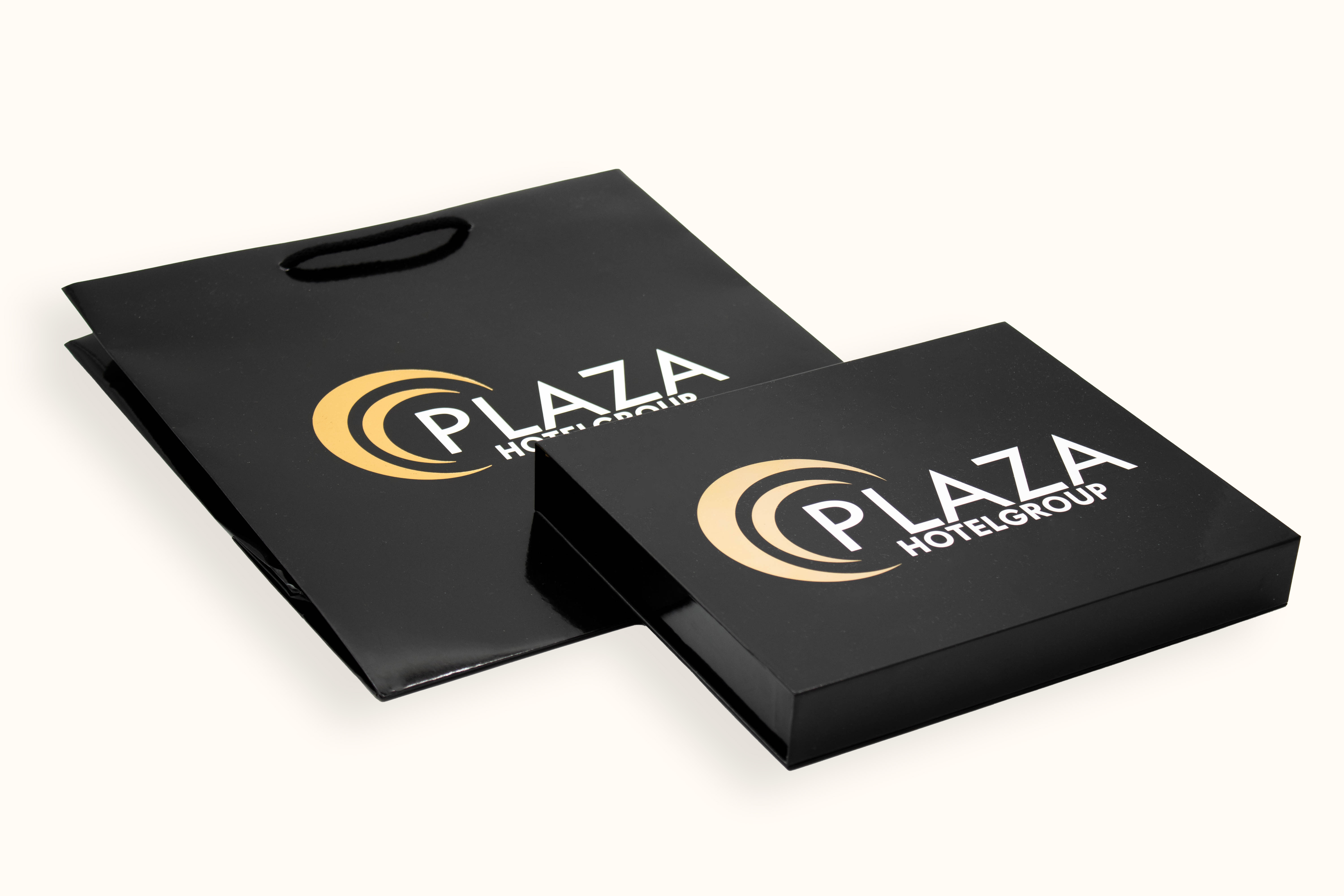Schwarze Geschenkbox und Papiertasche mit Plaza Hotelgroup Logo