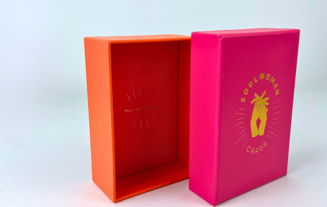 Orangefarbener Geschenkkarton bedruckt mit einem goldenen Logo.