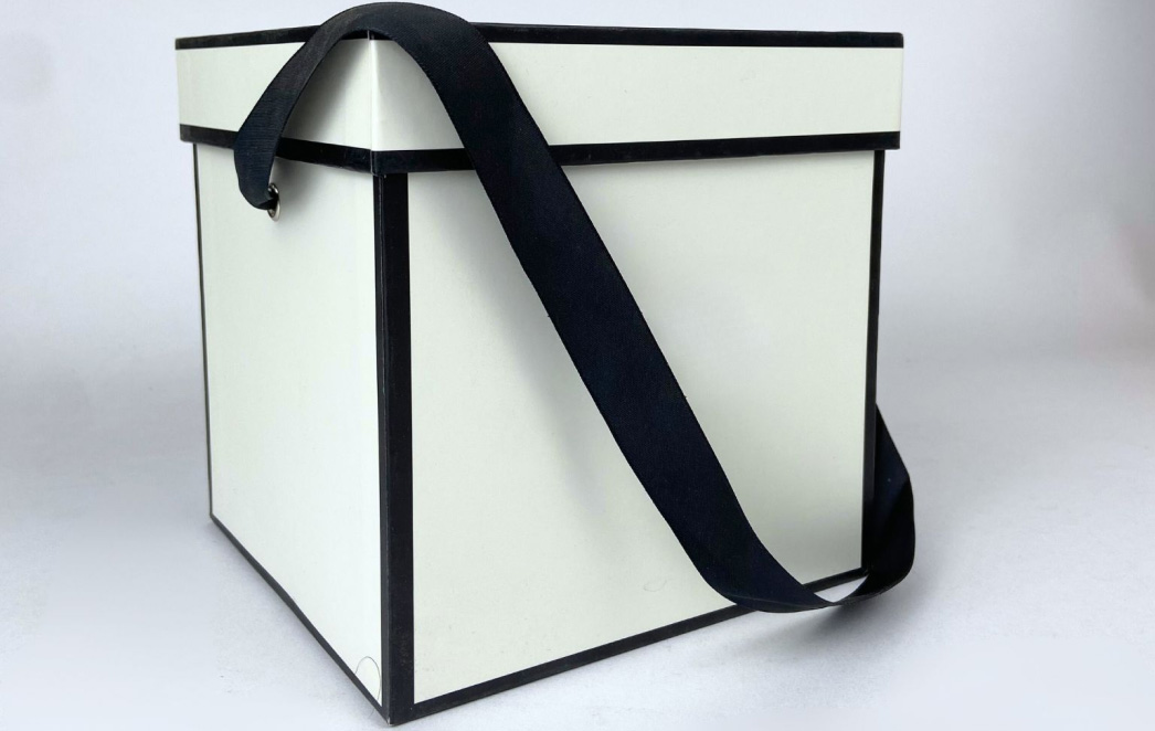 Schwarz-weißer Geschenkkarton mit passendem Band, der bedruckt werden kann.