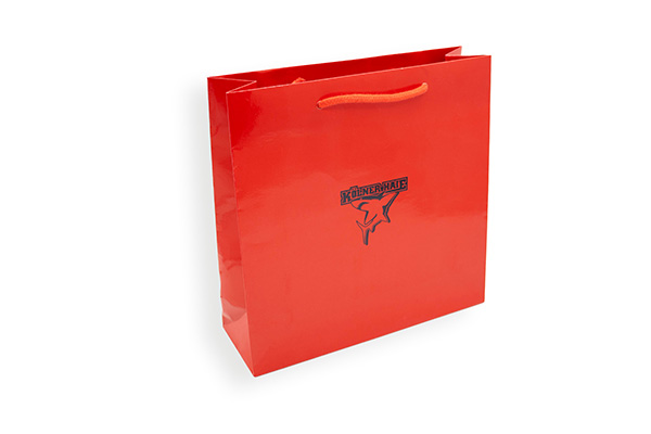 Rote glänzende Papiertragetasche mit Kordelgriff und Kölner-Haie-Logo