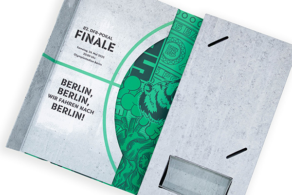 Aufgeklappte graue Klappbox mit grünem Innendruck zum DFB-Pokal-Finale 2025 in Berlin