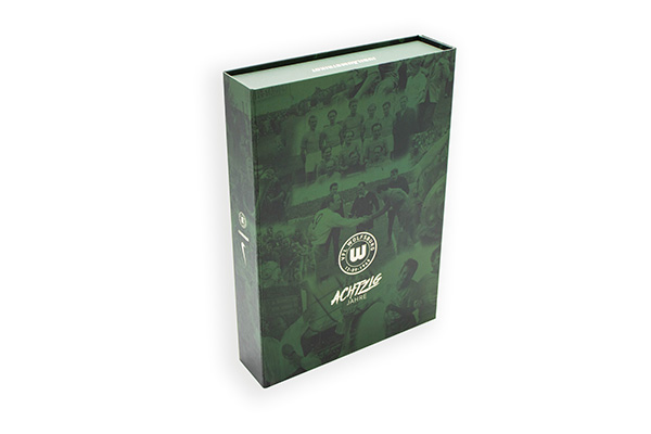 Geschlossene grüne Magnetbox mit VfL-Wolfsburg-Logo und Jubiläums-Schriftzug „Achtzig Jahre“